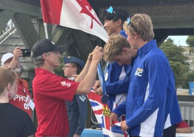 Tom Davis placing a gold medal around the neck of Canada Games Participant